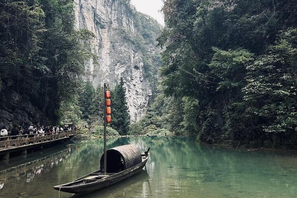 a boat in a river with people on a bridge