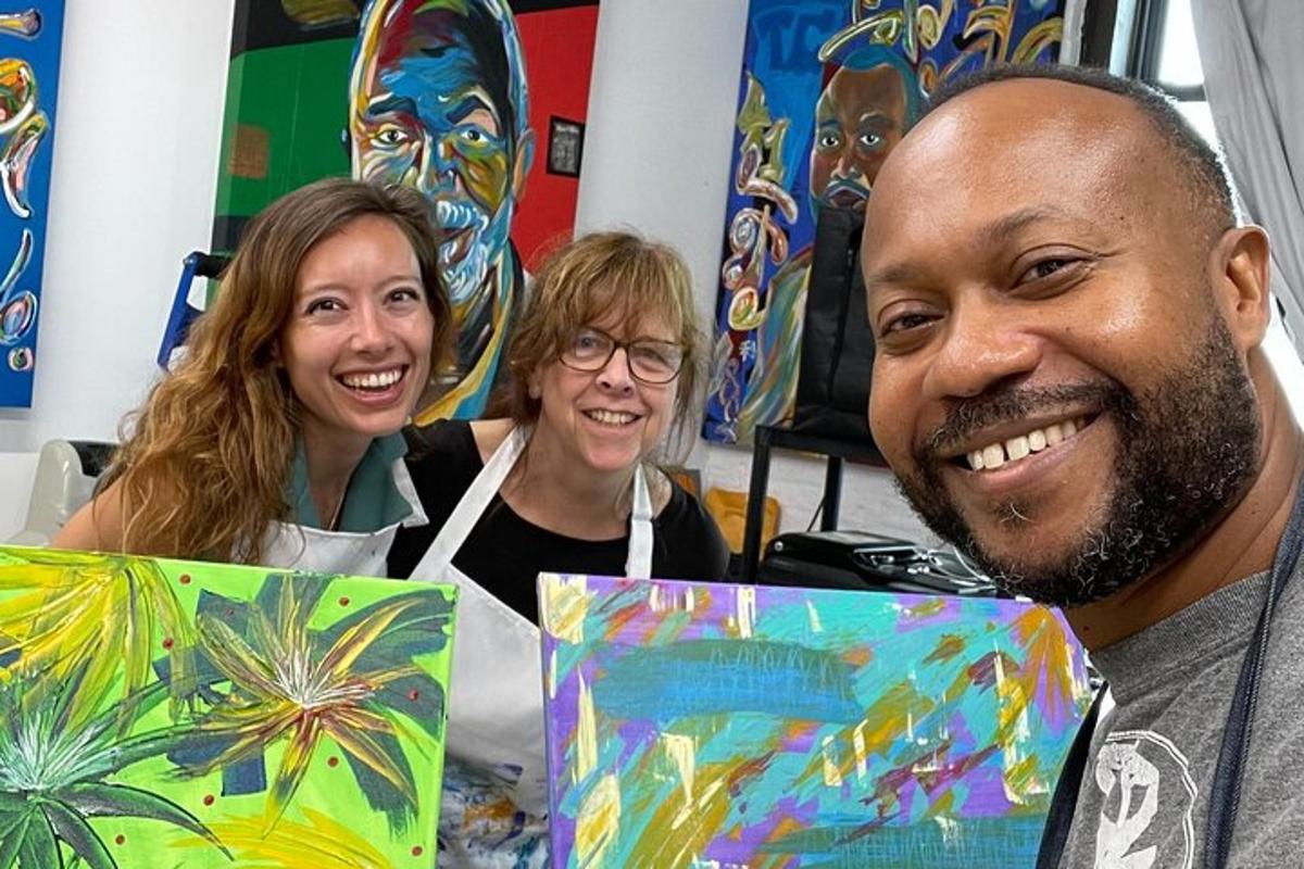 a man and two women holding paintings of masks