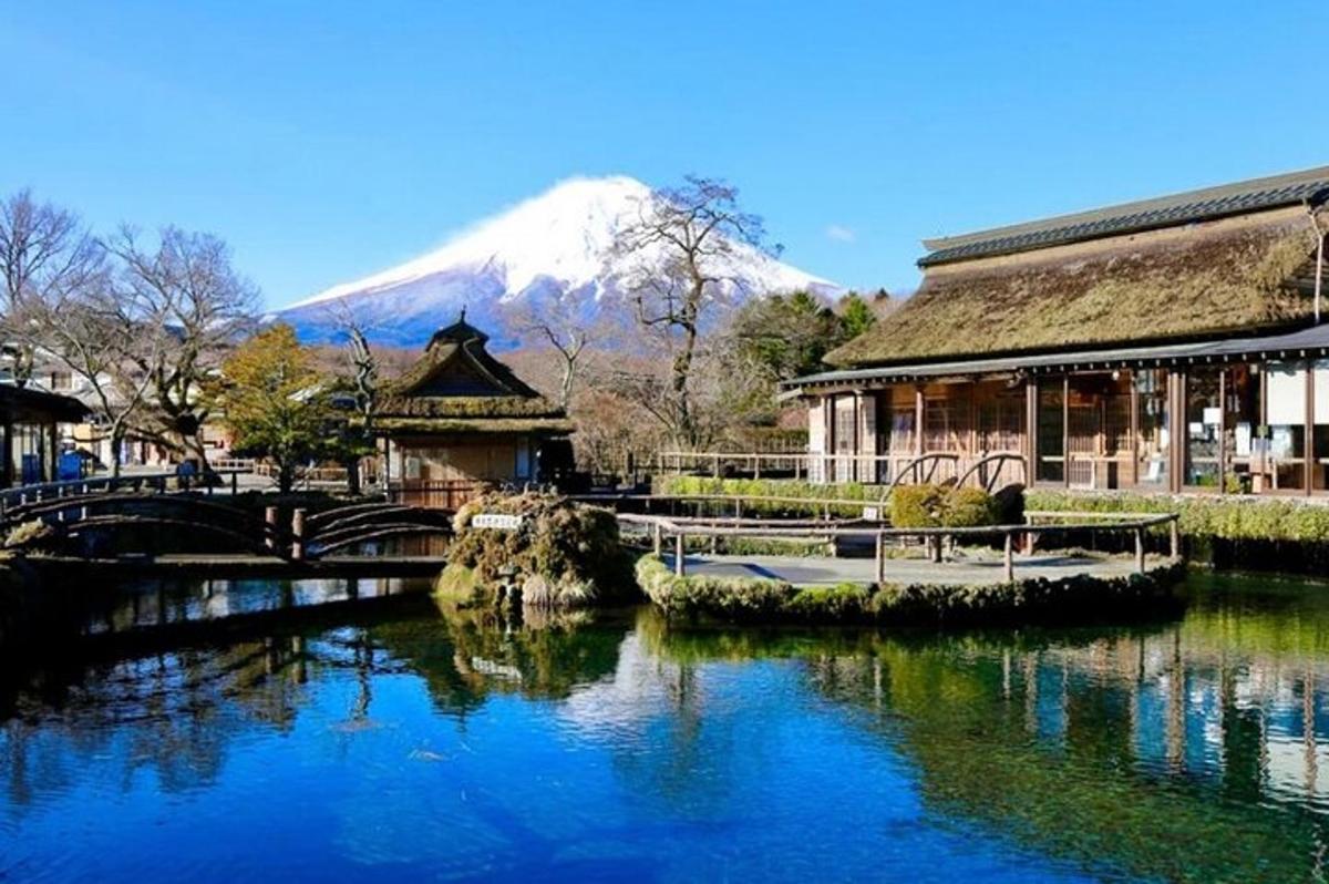 un edificio accanto a un fiume con una montagna sullo sfondo