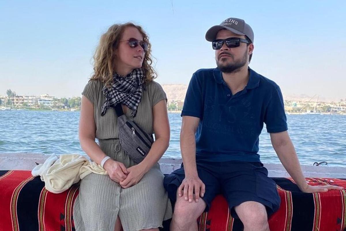 ένας άντρας και μια γυναίκα κάθονται στο πίσω μέρος μιας βάρκας