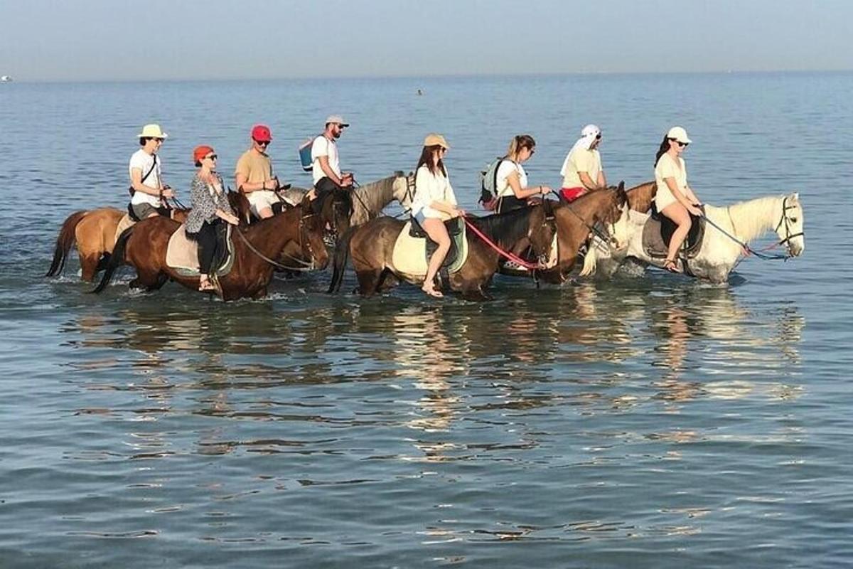 Un grupo de personas montando a caballo en el agua.