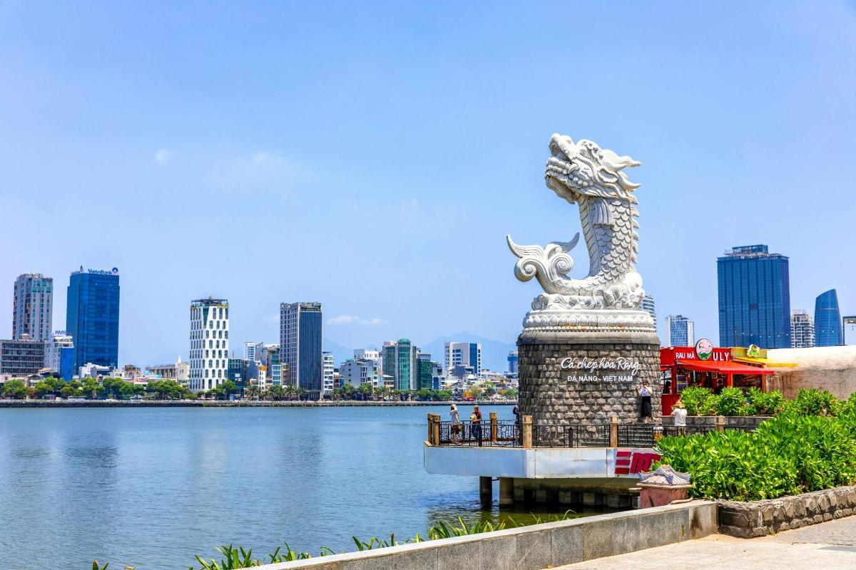 una statua accanto a uno specchio d'acqua con una città