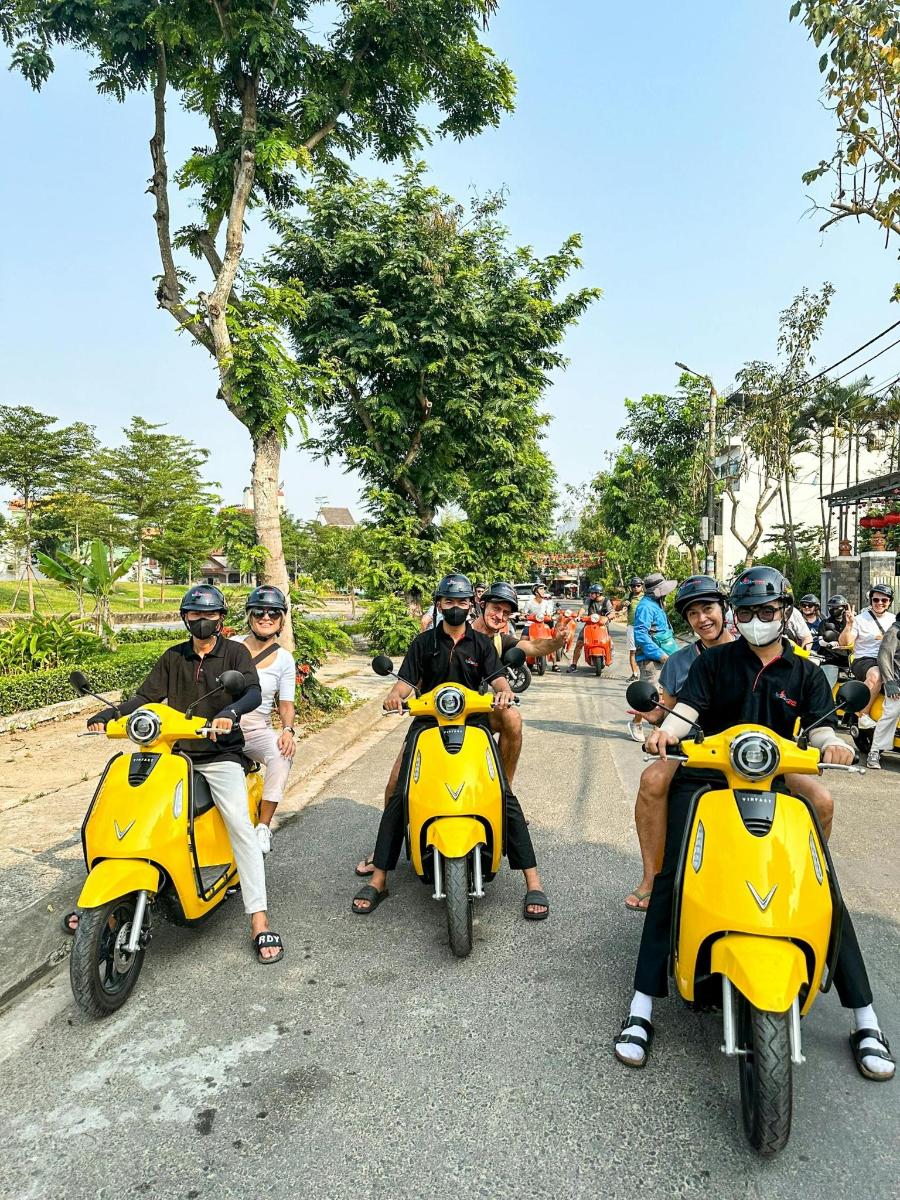 skupina lidí jedoucích na žlutých motorkách