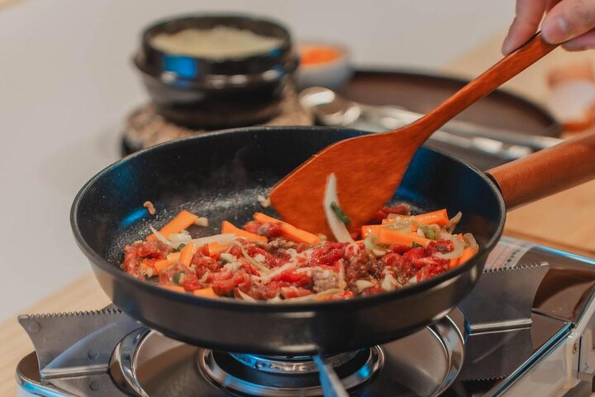 una persona che cucina il cibo in una padella su un fornello