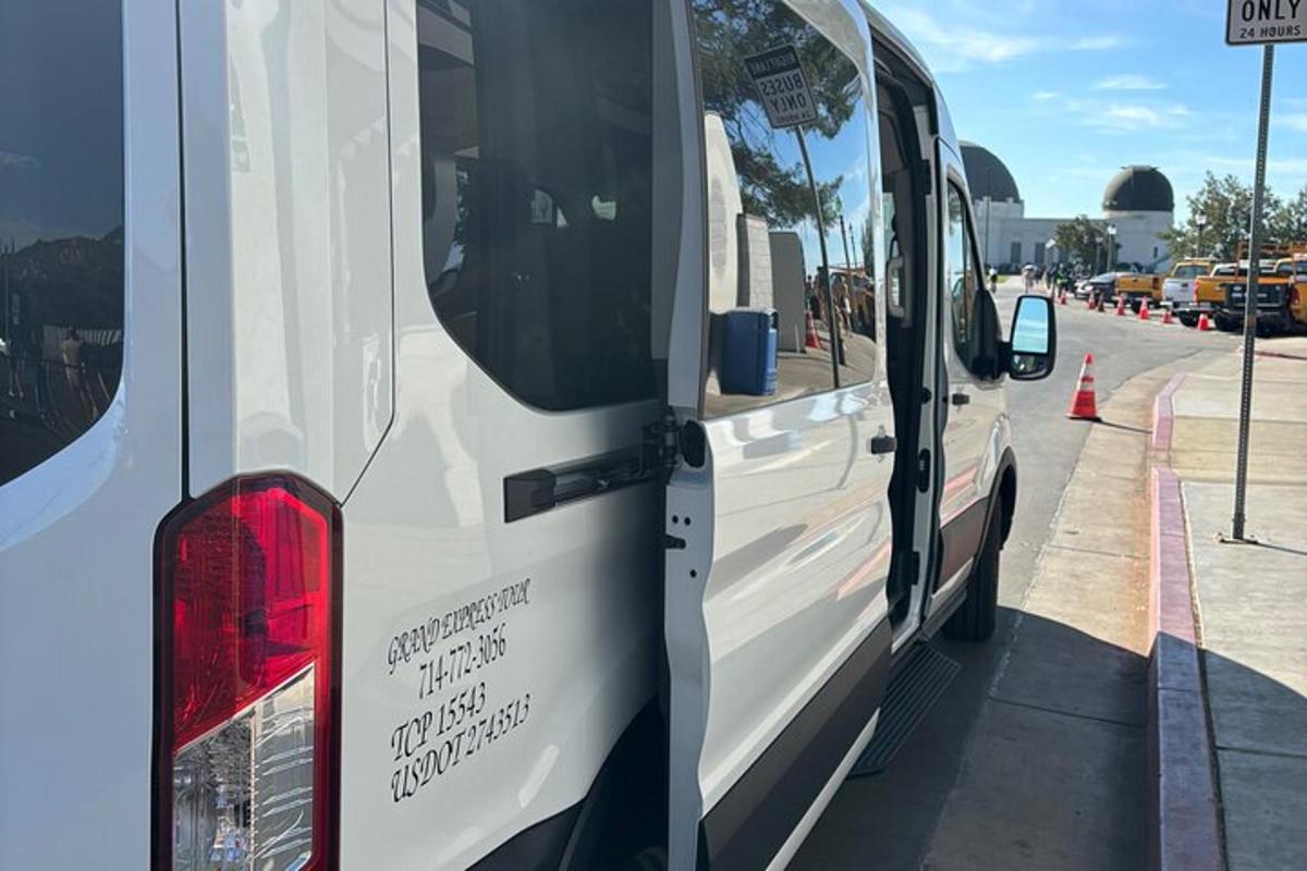 una camioneta blanca estacionada al costado de una calle