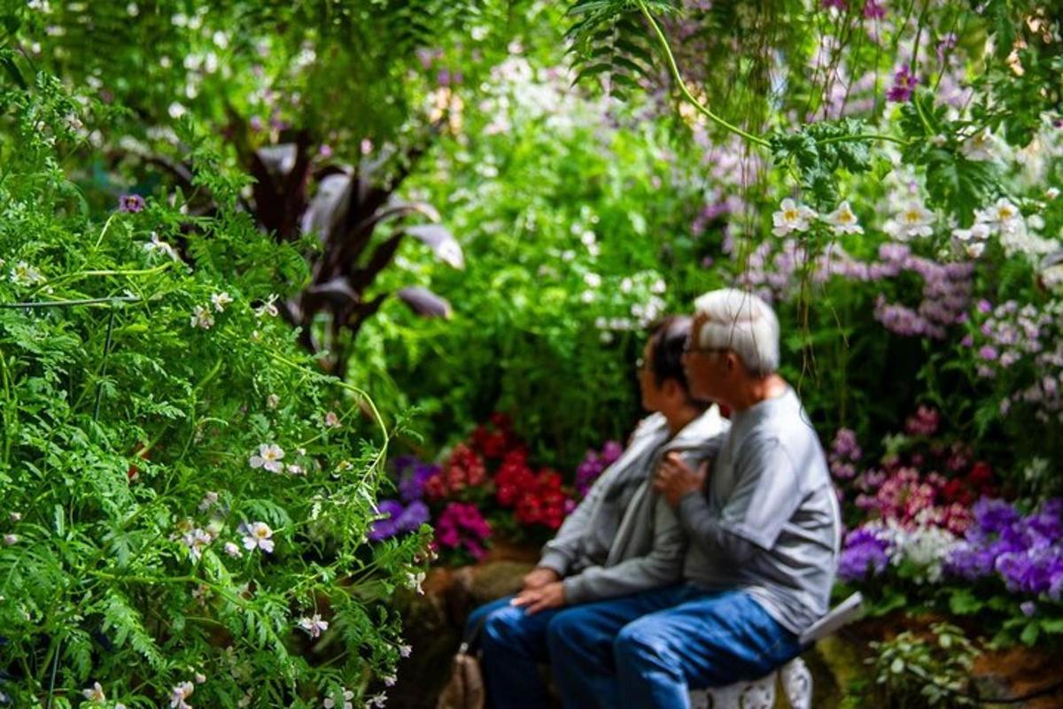 dva človeka sedita na klopi na vrtu