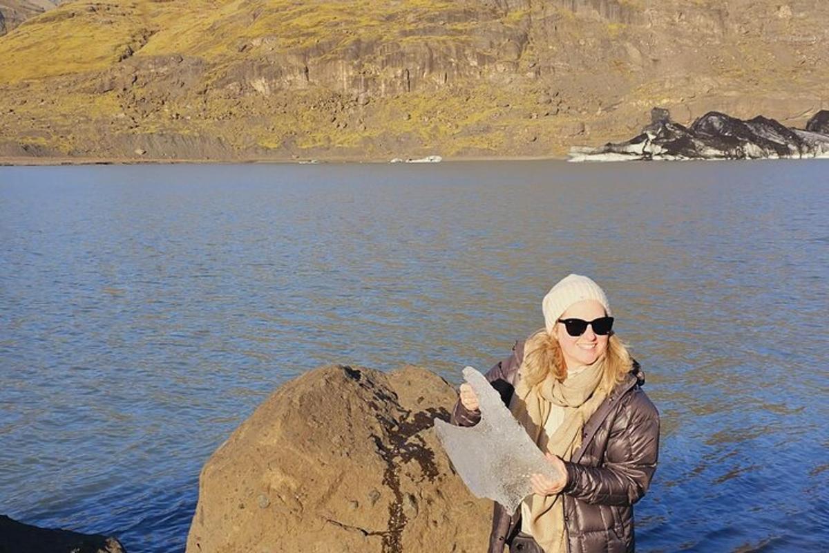 una donna in piedi su una roccia accanto a uno specchio d'acqua