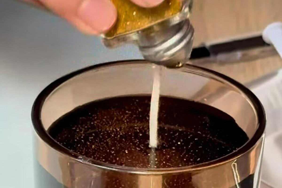 seseorang sedang menuang cecair ke dalam periuk makanan