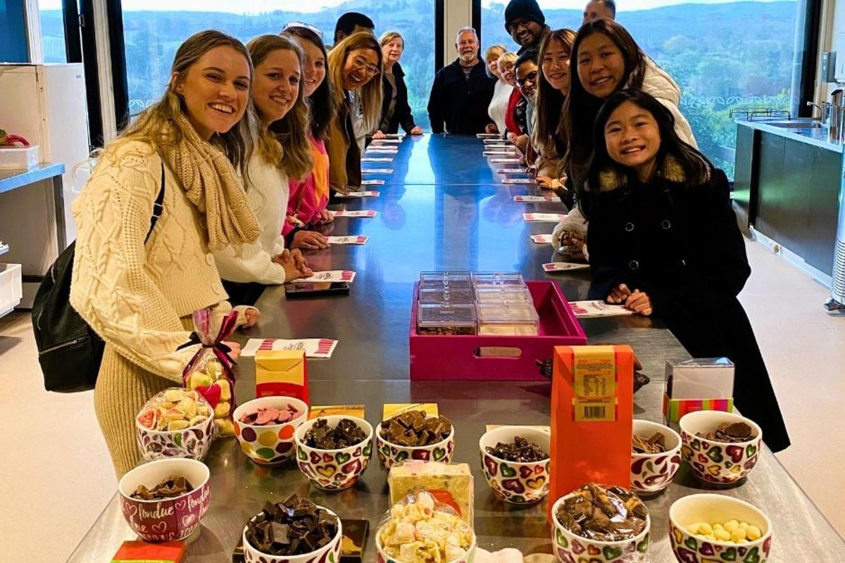 a group of women standing around a table with food