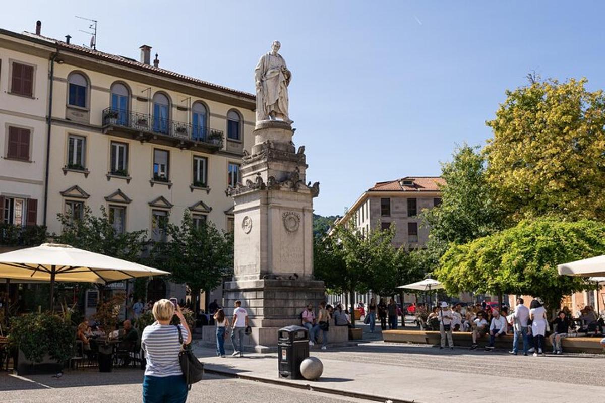a woman standing in front of a statue in a street