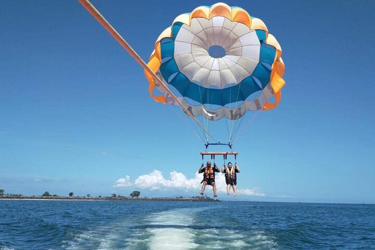 two people are riding a hot air balloon over the water