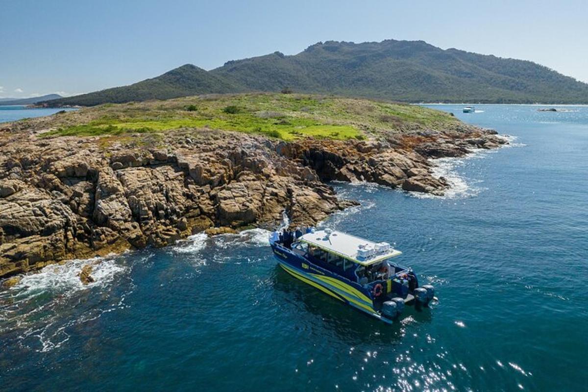 a boat in the water near a rocky island