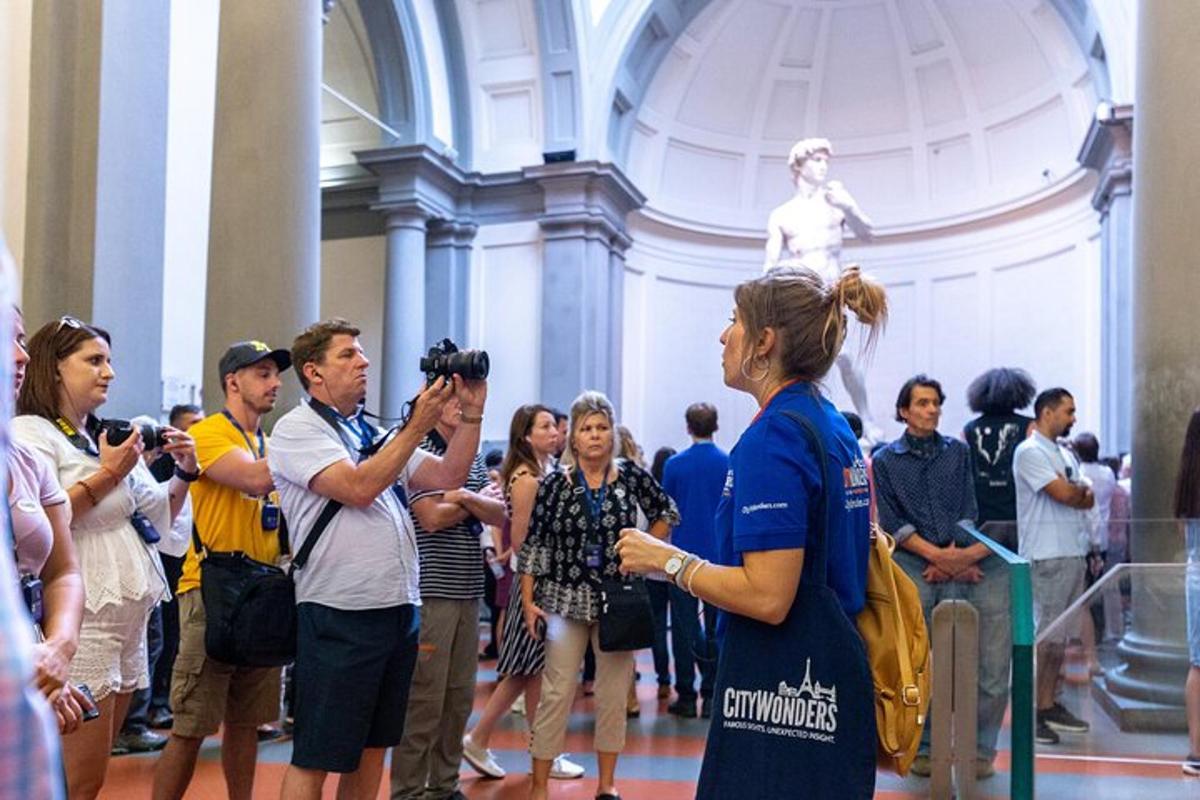 um grupo de pessoas tirando fotos de uma estátua
