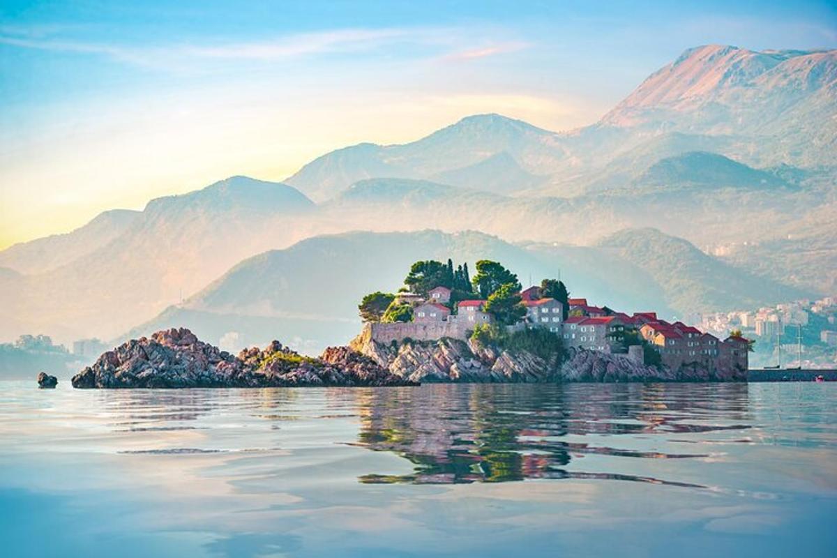 an island in the water with mountains in the background