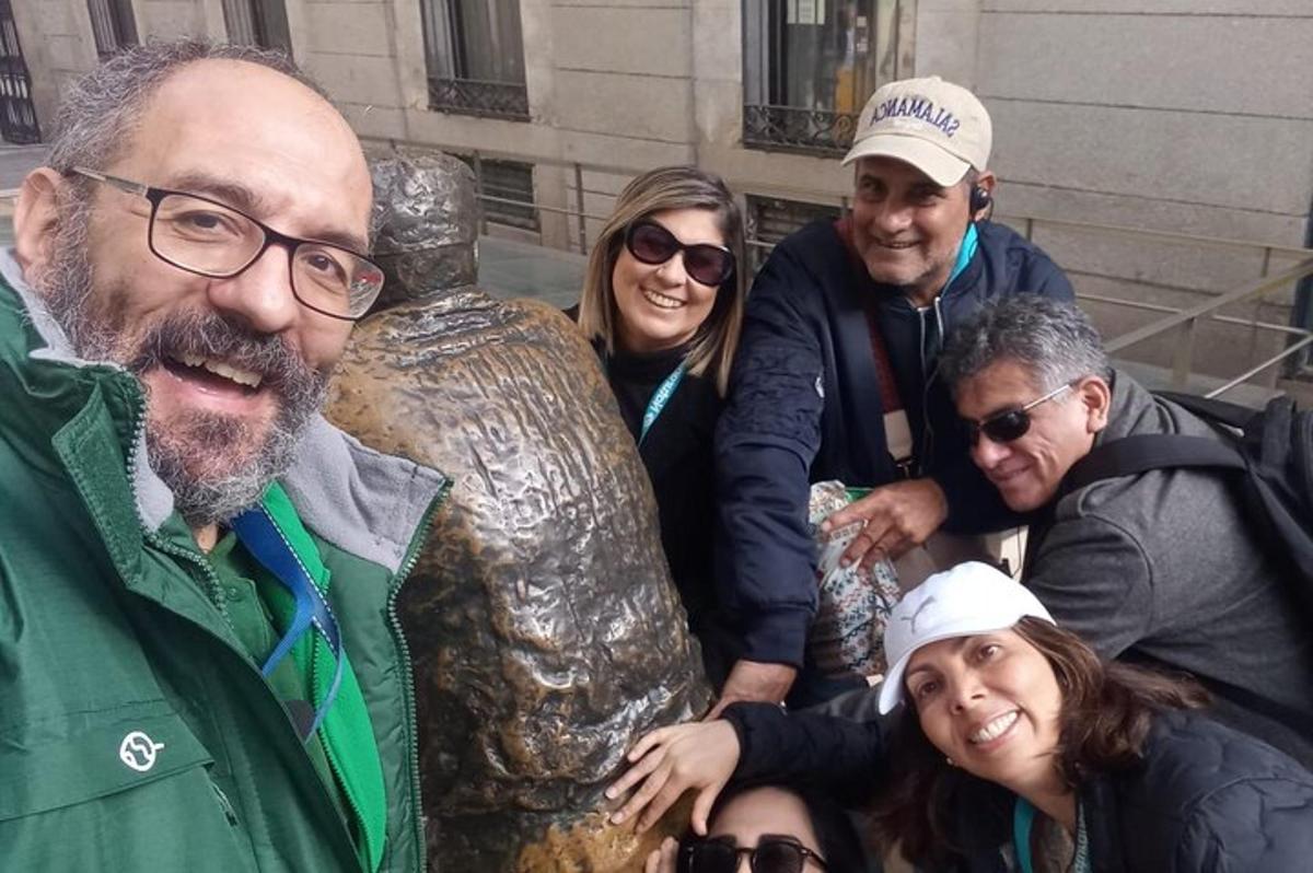 un gruppo di persone in piedi accanto a una statua
