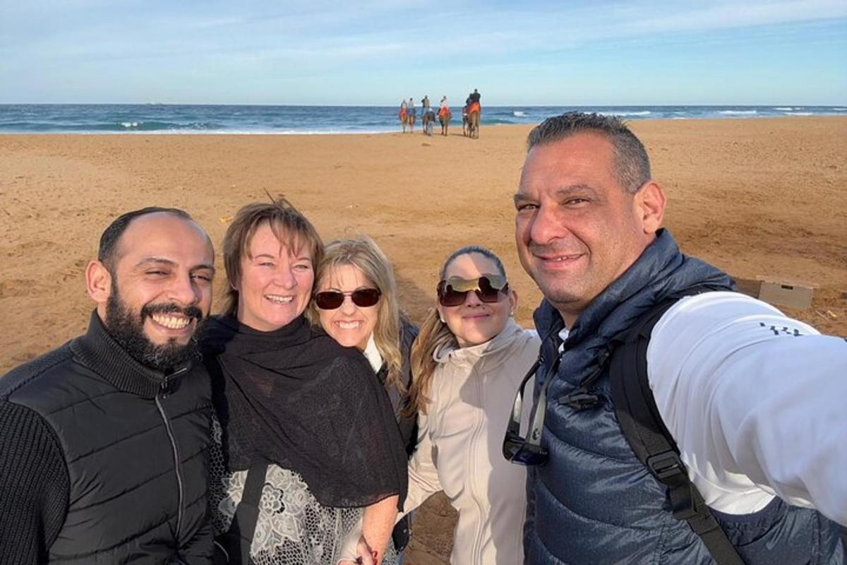 a group of people posing for a picture on the beach