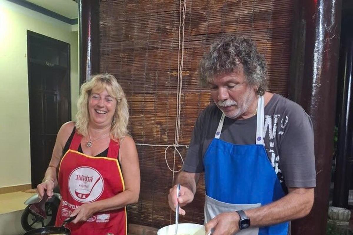 moški in ženska v kuhinji pripravljata hrano