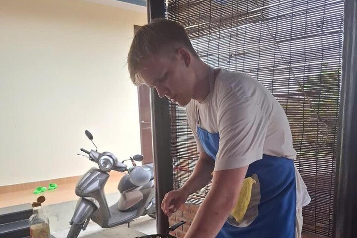 vīrietis stāv motocikla priekšā