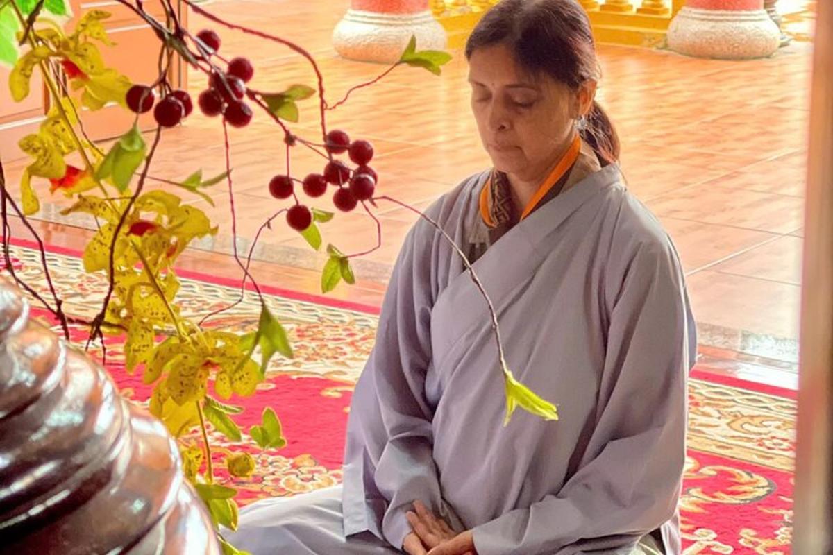 una donna seduta in meditazione accanto a una pianta
