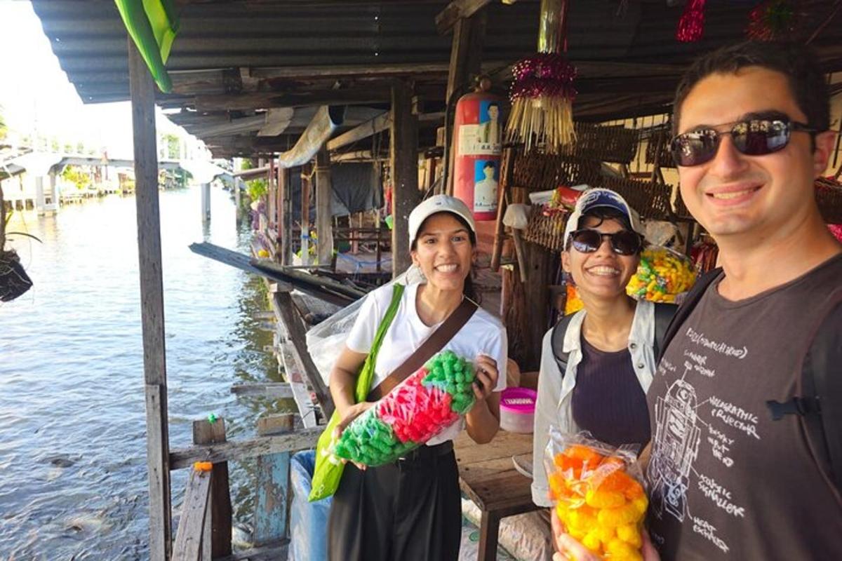 Un hombre y dos mujeres de pie frente a un mercado.