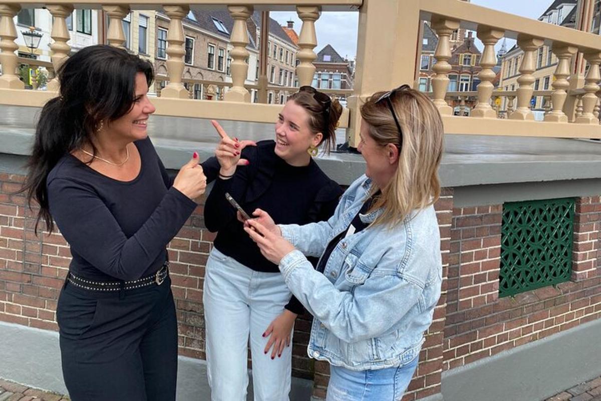 tři ženy stojící vedle sebe a dívající se na mobilní telefon