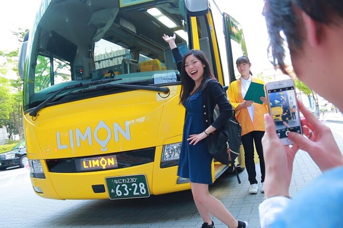 en mann som tar et bilde av en kvinne som står foran en buss