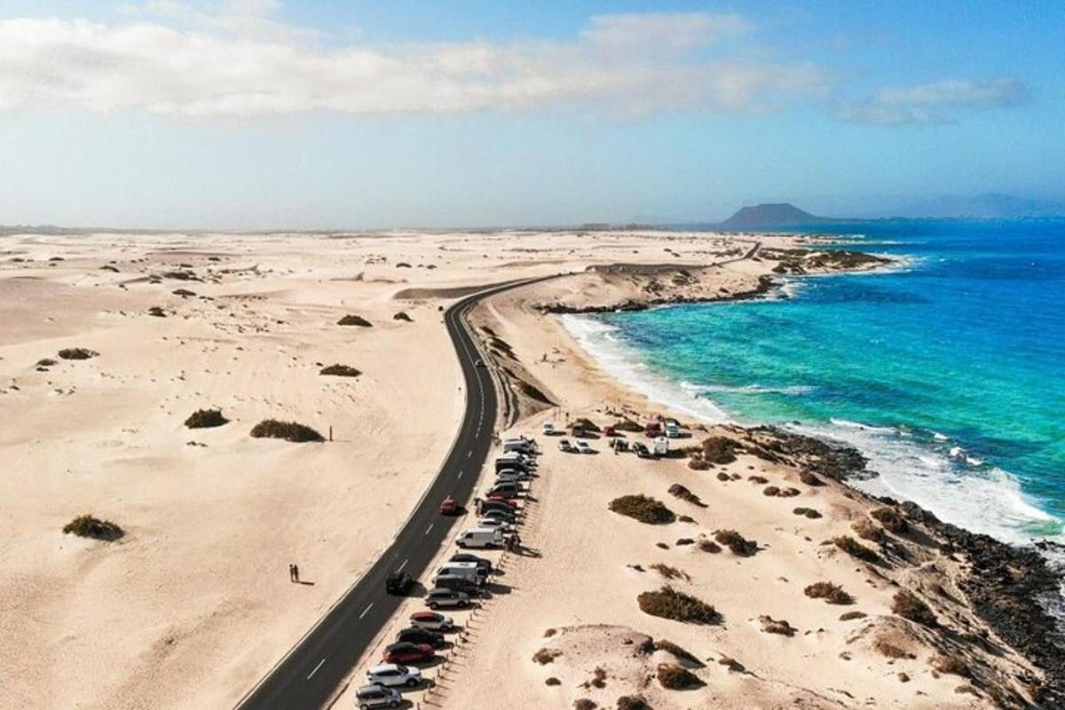 a road on a beach next to the ocean