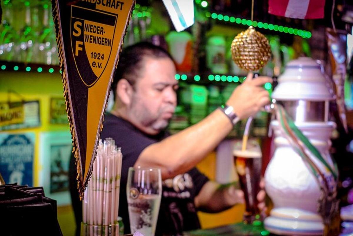seorang lelaki sedang membuat minuman di sebuah bar