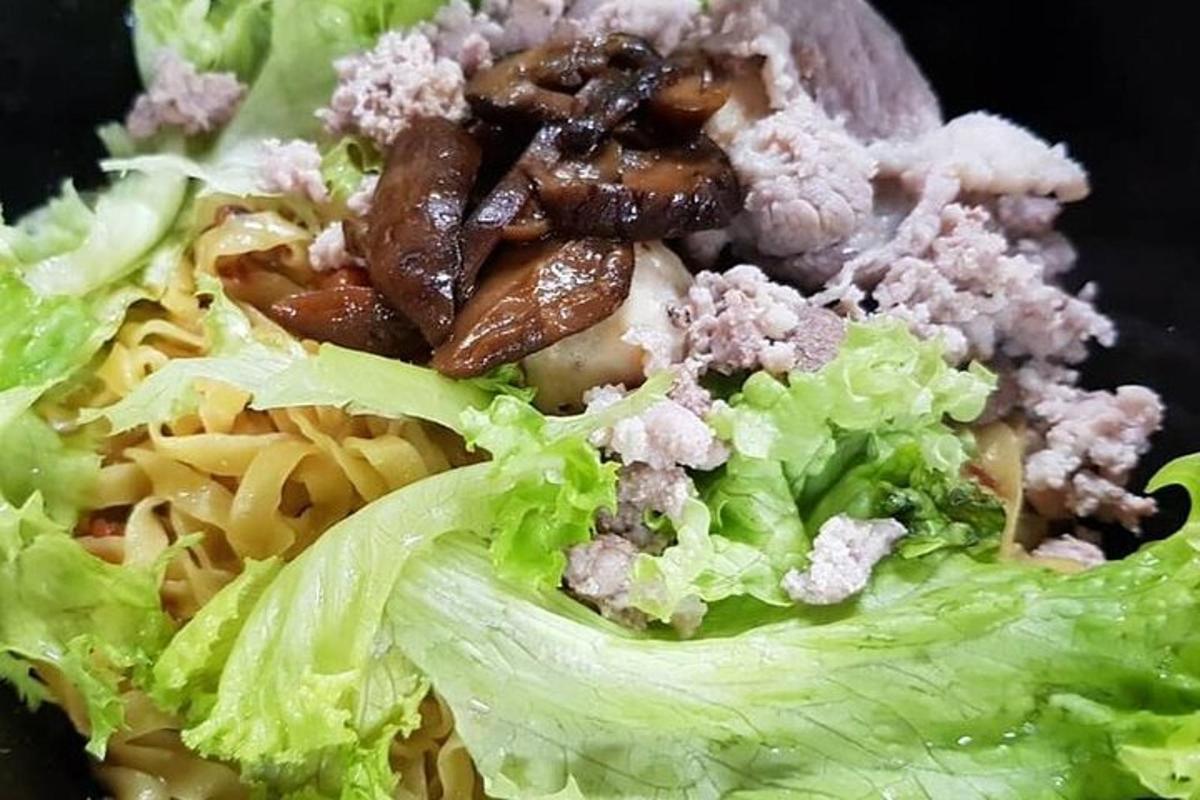 レタス、肉、ナッツが添えられた料理の皿