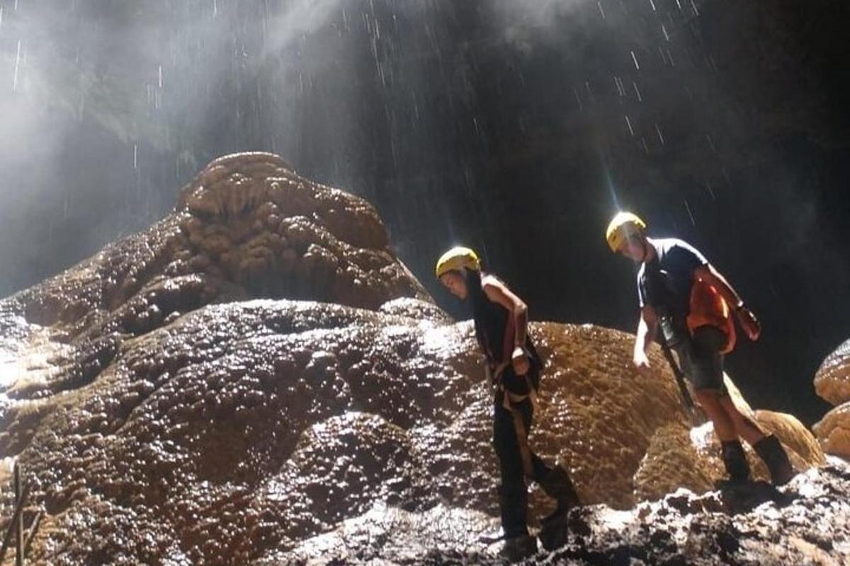 due persone che camminano sulle rocce in una grotta