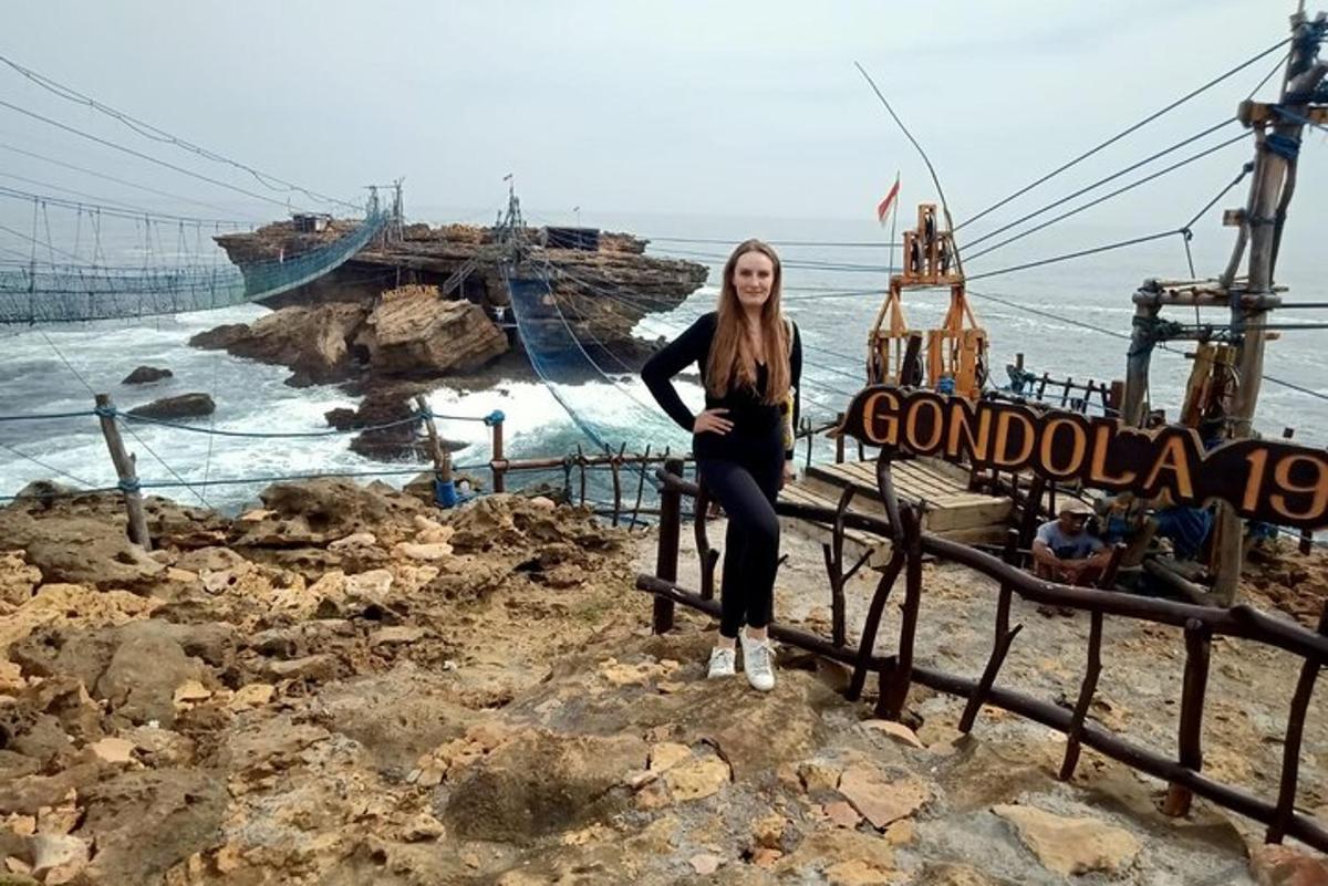 una donna seduta su una staccionata vicino all'oceano