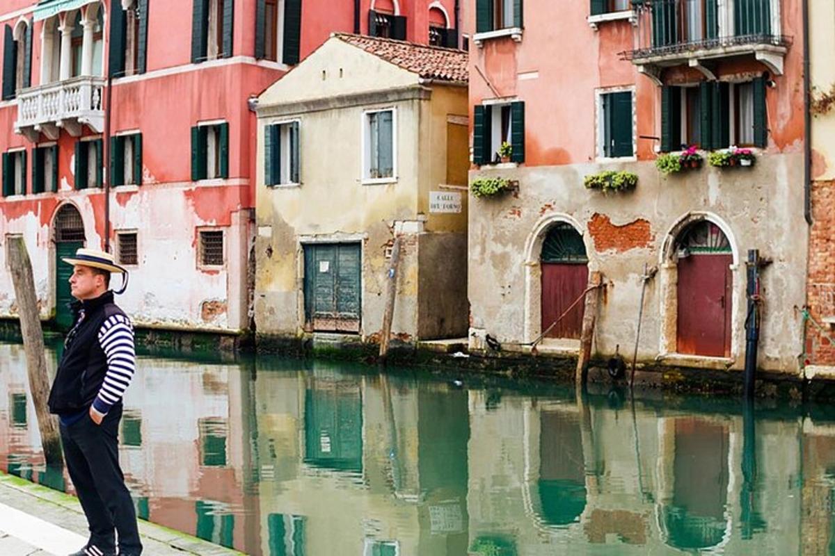 a man standing on a sidewalk next to a canal
