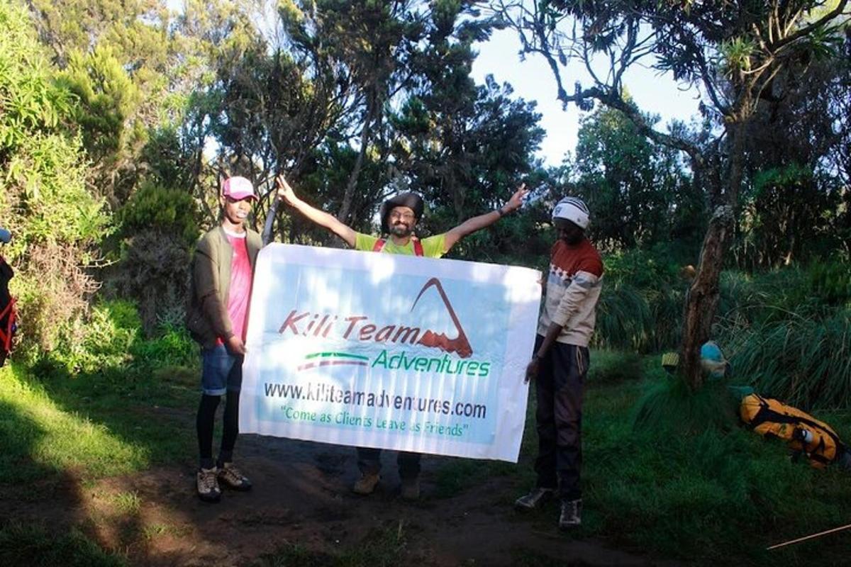a group of people holding a sign on a trail