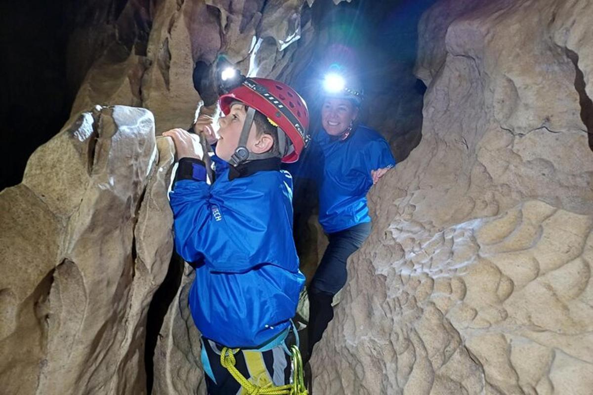 two men are climbing in a cave