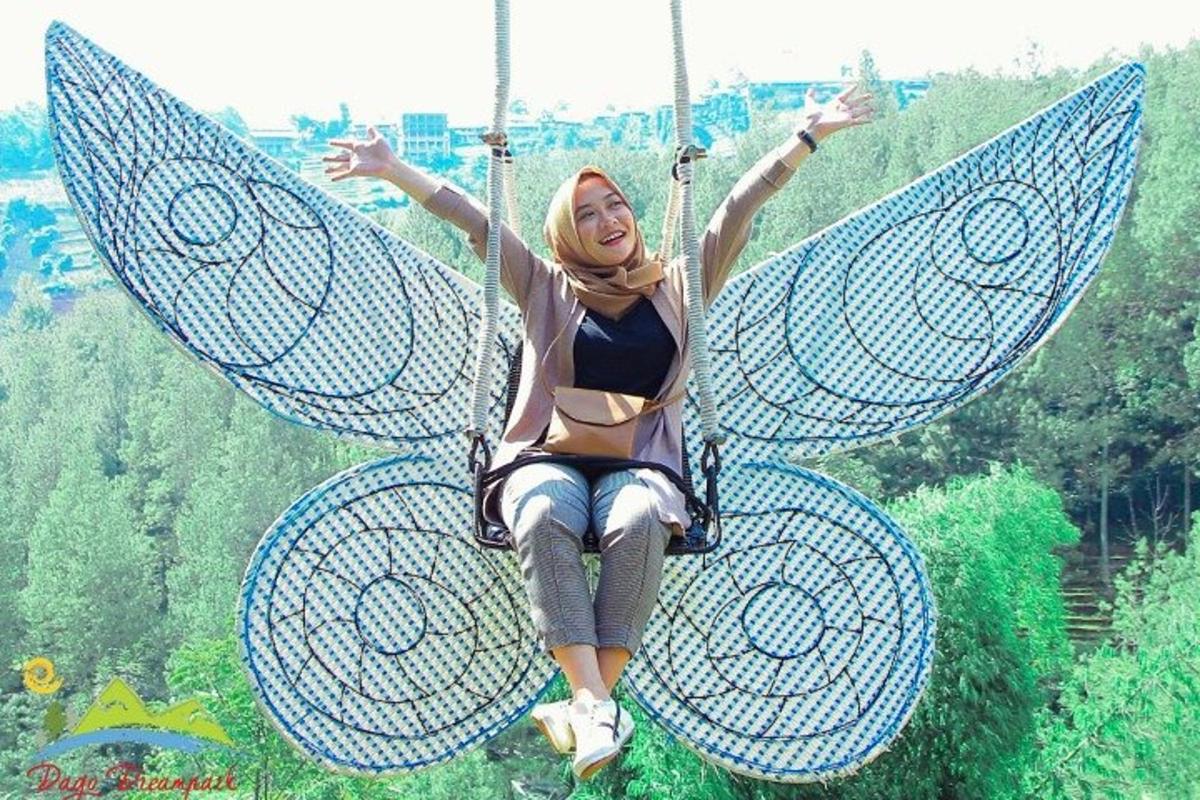 a woman is sitting on a butterfly swing