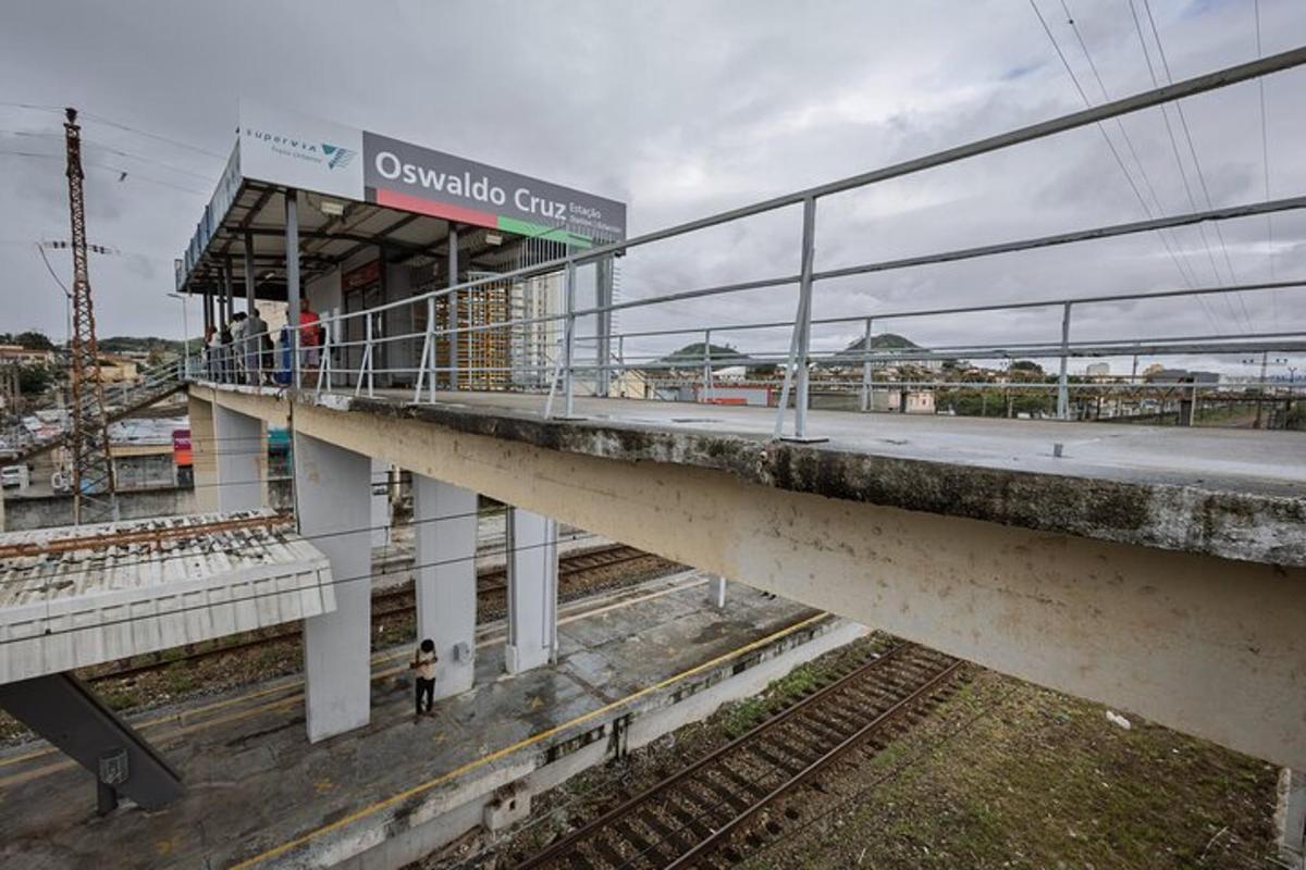 uma estação de trem com pessoas esperando na plataforma