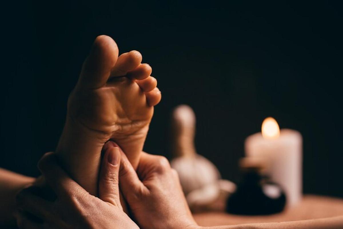 osoba, která si pokládá nohy na stůl se svíčkou