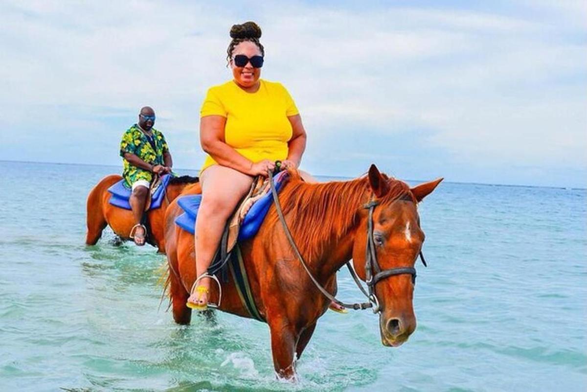 žena jedoucí na koni v oceánu