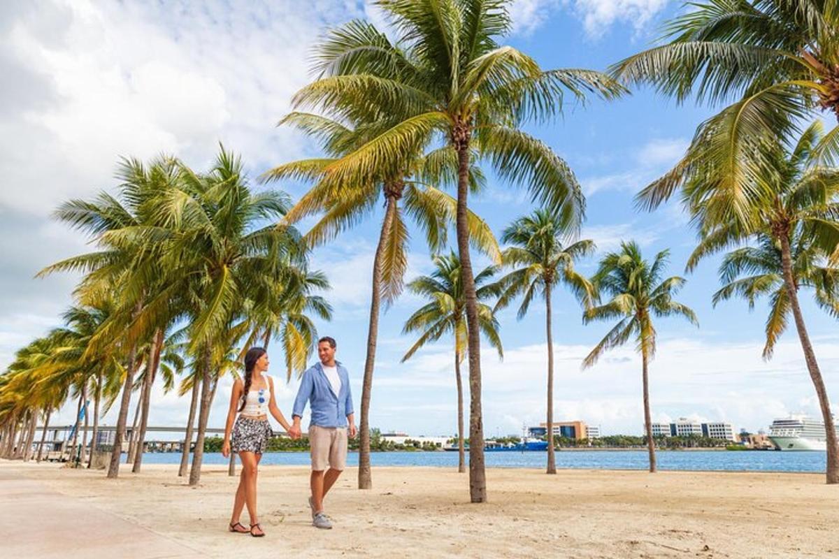 Un hombre y una mujer caminando por una playa con palmeras