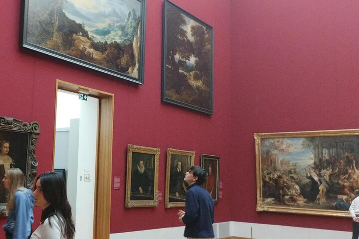 lidé stojící v muzeu a prohlížející si obrazy
