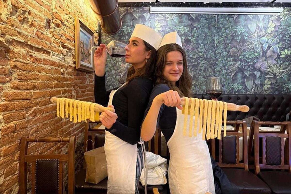 dues dones dretes una al costat de l'altra sostenint un manat de pasta