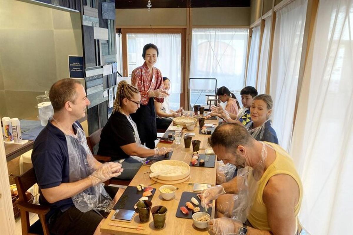 un grup de persones assegudes al voltant d'una taula menjant sushi