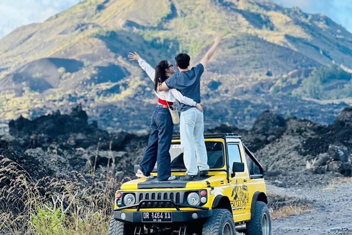 un uomo e una donna in piedi sul tetto di una jeep