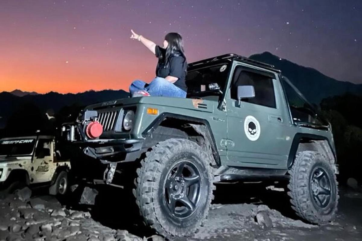 a woman sitting on the top of a jeep
