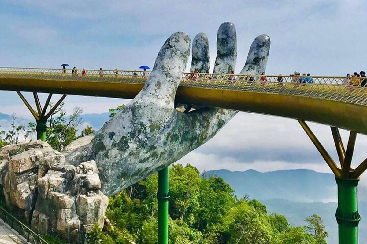 una grande statua di una mano protesa da sotto un ponte