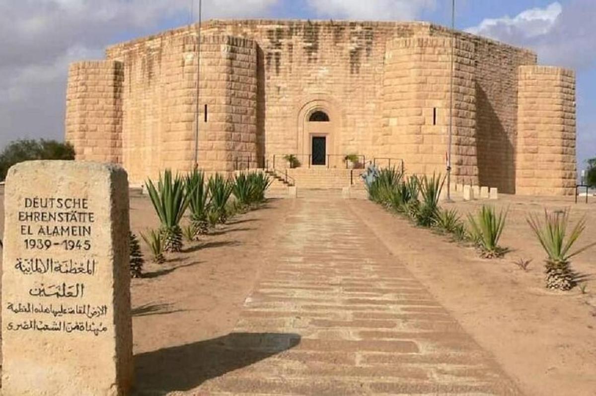 un grande edificio in mattoni con un cartello davanti