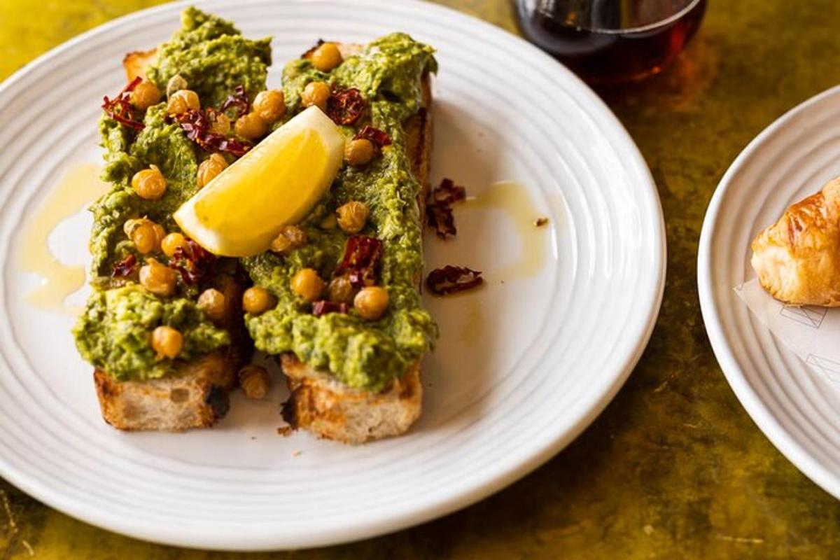 um prato branco com um pedaço de pão com pesto e nozes