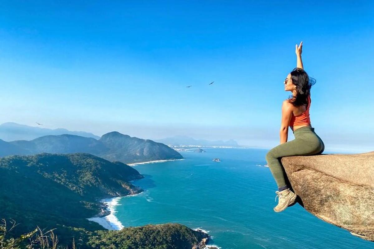 žena sedící na skále s výhledem na oceán
