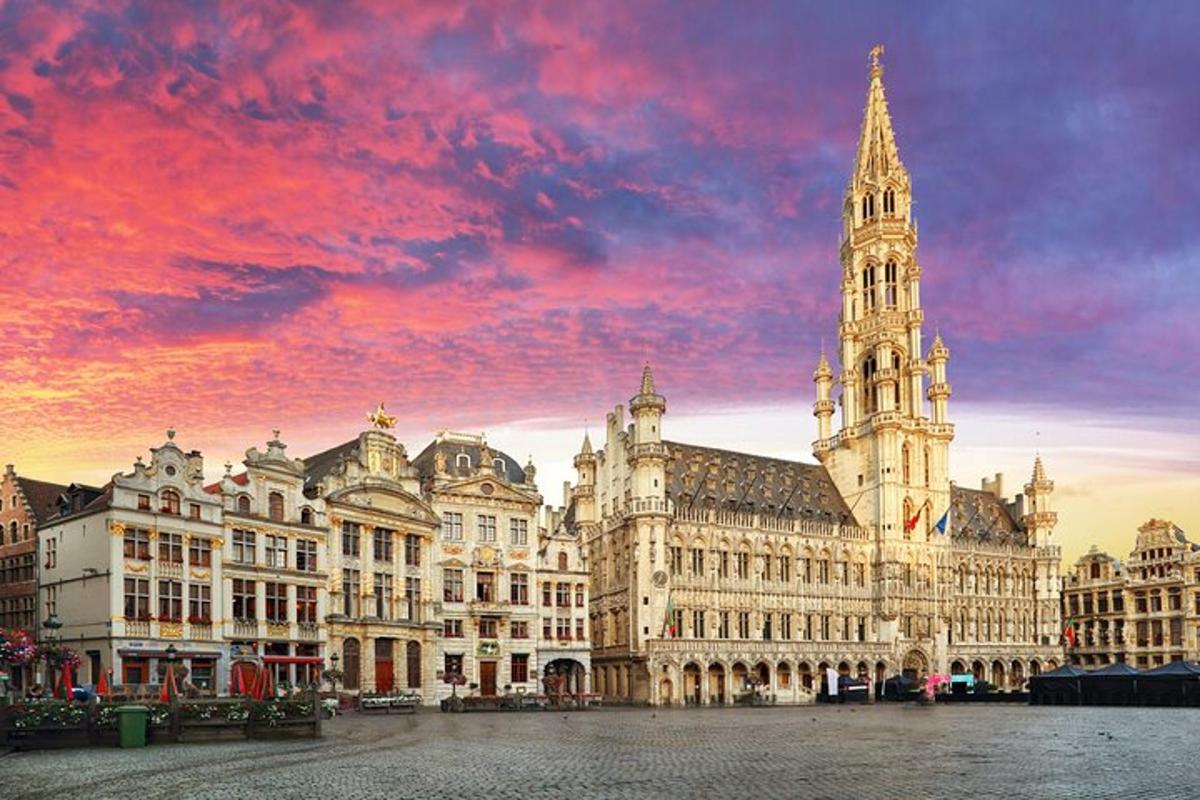 um grande edifício com uma torre do relógio com um pôr do sol