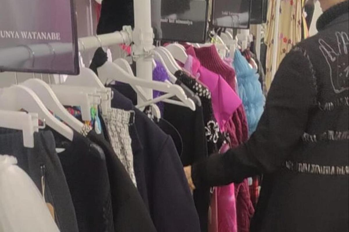 a person standing in a rack of clothes